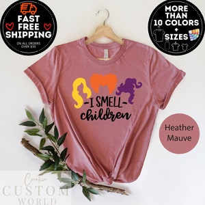 May include: A heather mauve t-shirt with a graphic of three witches with the text "I Smell Children".