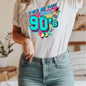 May include: White t-shirt with a colorful 90s graphic that says "TAKE ME BACK TO THE 90's". The design includes teal, pink, and yellow accents. The shirt is paired with blue jeans. The image also includes text about fast, free shipping and more than 10 colors and sizes.