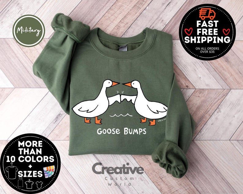 Puede incluir: Una sudadera verde con un dise&ntilde;o de piel de gallina blanca y el texto "Goose Bumps".