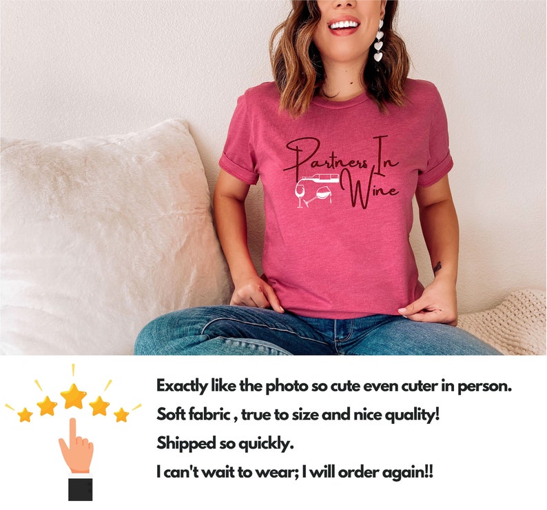 Puede incluir: Una camiseta rosa con el texto "Partners In Wine" en letra cursiva. El texto est&aacute; acompa&ntilde;ado por una peque&ntilde;a ilustraci&oacute;n de un coche con dos copas de vino.
