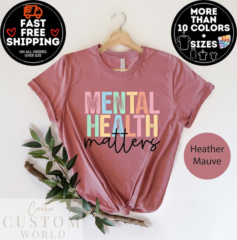 May include: A heather mauve t-shirt with the text "MENTAL HEALTH matters" in rainbow colours. The text has a distressed, glittery look.