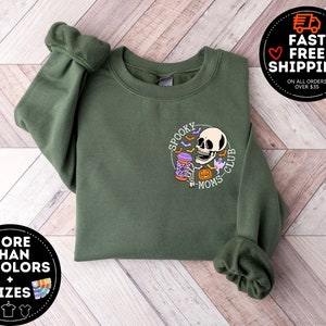 May include: Green sweatshirt with a graphic of a skull holding a potion with the text "Spooky Moms Club".