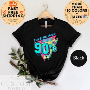 May include: Black t-shirt with a retro design that says "TAKE ME BACK TO THE 90's" in teal, pink, and yellow. The shirt is hanging on a wooden hanger. The shirt is available in more than 10 colors and sizes.