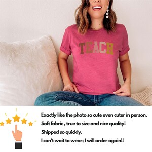 Może przedstawiać: R&oacute;żowy T-shirt z nadrukiem słowa "TEACH" w brązowych, pomarańczowych i beżowych literach. Koszulkę nosi osoba siedząca na białej kanapie.