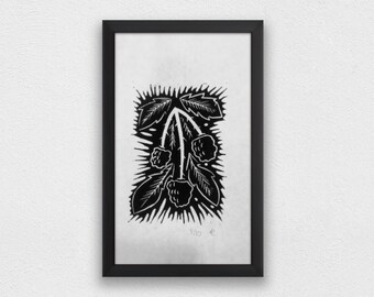Puede incluir: Grabado en linóleo en blanco y negro de un arbusto de moras estilizado con hojas y bayas. La impresión está enmarcada en un marco negro.