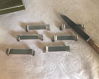 Série de 8 portes couteaux de la marque Christofle en métal