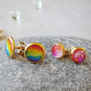 May include: A white ceramic mug with a black handle and the text "But First, Coffee" in a bold, black font. The mug is set against a blurred background, suggesting a cozy setting.