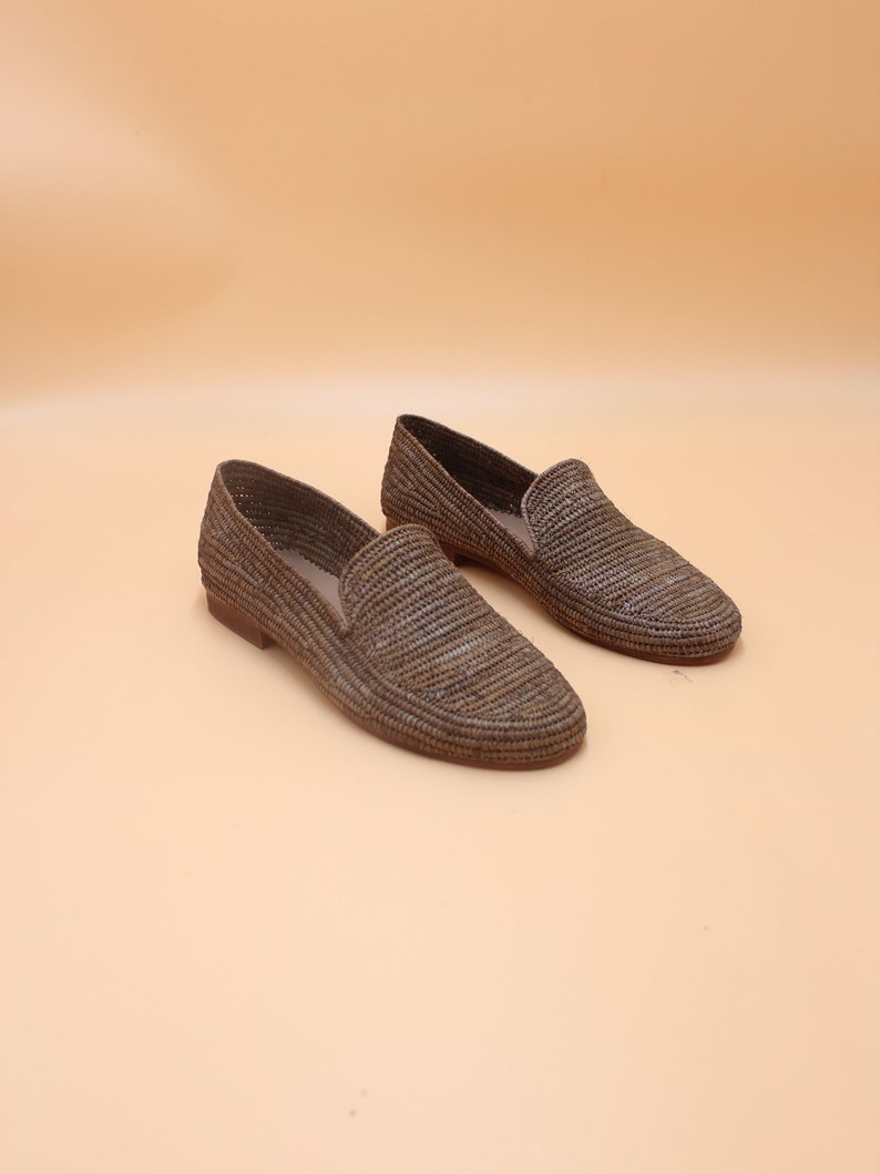K&ouml;nnte beinhalten: Ein Paar braune geflochtene Lederschuhe. Die Schuhe haben eine spitze Zehenpartie und eine flache Sohle.