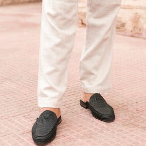 May include: A pair of black woven leather slip-on shoes with a pointed toe.