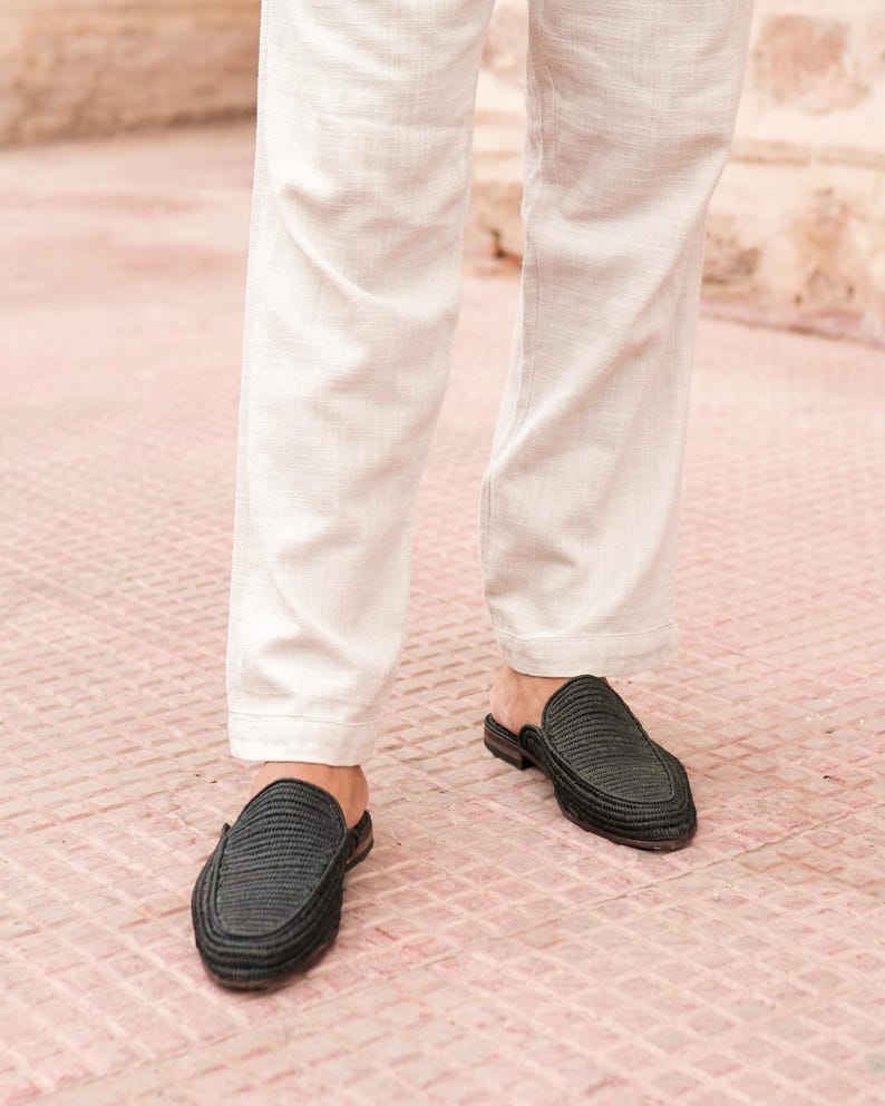 May include: A pair of black woven leather slip-on shoes with a pointed toe.
