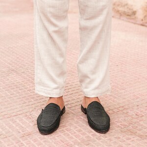 May include: A pair of black woven leather slip-on shoes with a pointed toe.