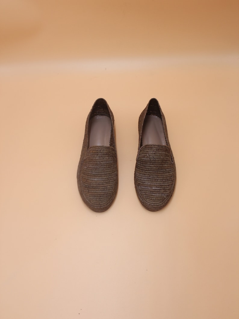 K&ouml;nnte beinhalten: Ein Paar braune geflochtene Lederschuhe. Die Schuhe haben ein schlichtes Design und sind aus einem nat&uuml;rlichen Material gefertigt.