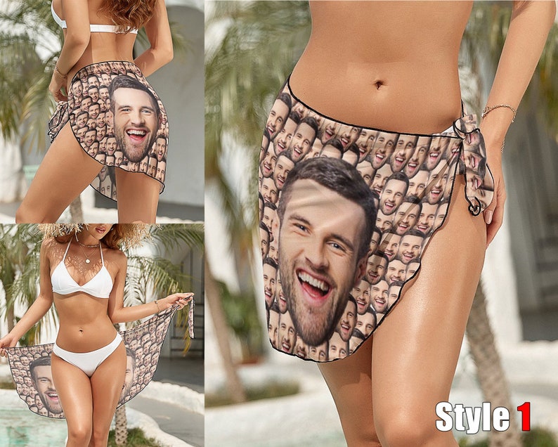 May include: A woman wearing a white bikini top and bottom is wearing a sarong with a pattern of many faces. The sarong is tied at the side and the woman is standing in front of a tropical background. The text "Style 1" is visible in the bottom right corner of the image.