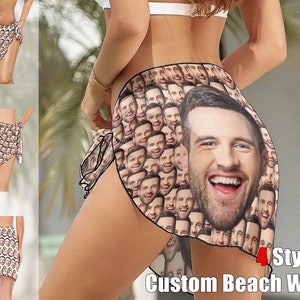 May include: A white beach wrap with a pattern of repeated faces. The wrap is tied around the waist and has a fringe on the bottom. The text "4 Styles Custom Beach Wrap" is visible at the bottom of the image.