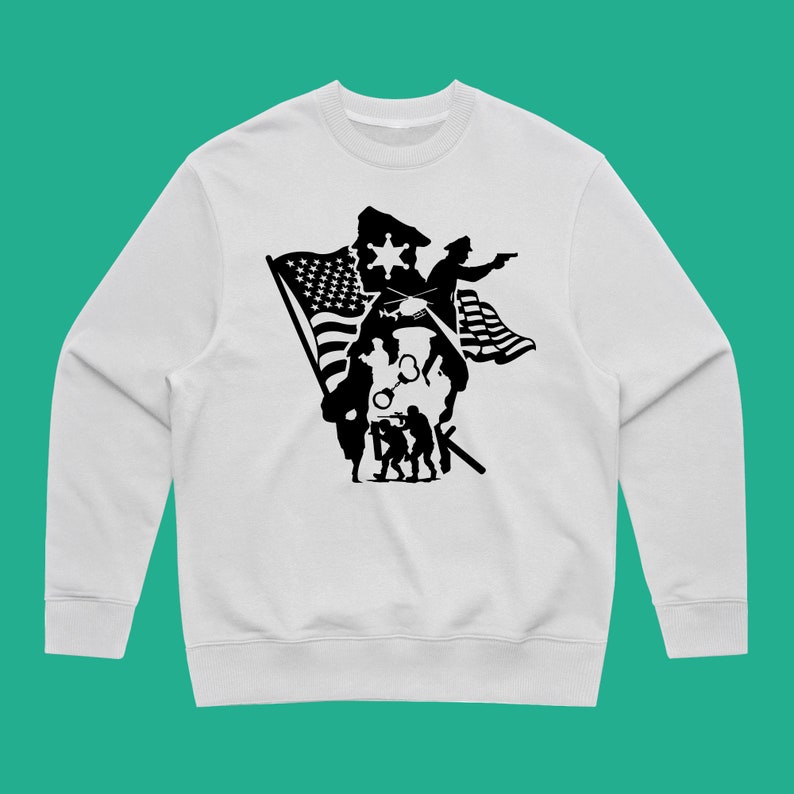K&ouml;nnte beinhalten: Wei&szlig;er Pullover mit einem schwarzen Silhouetten-Design eines Polizisten, Soldaten und einer amerikanischen Flagge.