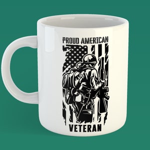 May include: White ceramic mug with a black and white graphic of a soldier standing in front of an American flag. The text "Proud American Veteran" is printed on the mug.