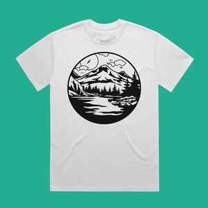 May include: White t-shirt with a black and white graphic of a mountain range, lake, and trees in a circle.