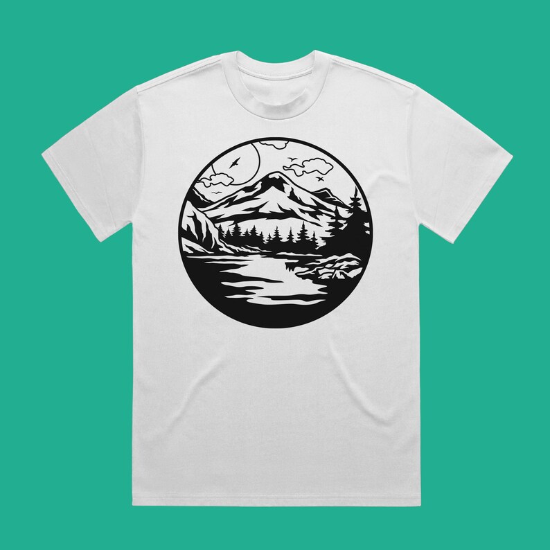 May include: White t-shirt with a black and white graphic of a mountain range, lake, and trees in a circle.