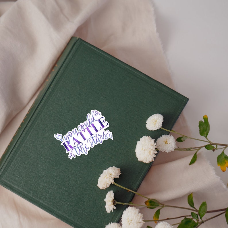 a sticker with the quote you could rattle the stars with purple and blue texture and four pointed stars, a quote by nehemia ytger, Aelins best friend from throne of glass by Sarah j Maas
