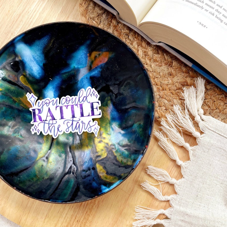 a sticker with the quote you could rattle the stars with purple and blue texture and four pointed stars, a quote by nehemia ytger, Aelins best friend from throne of glass by Sarah j Maas