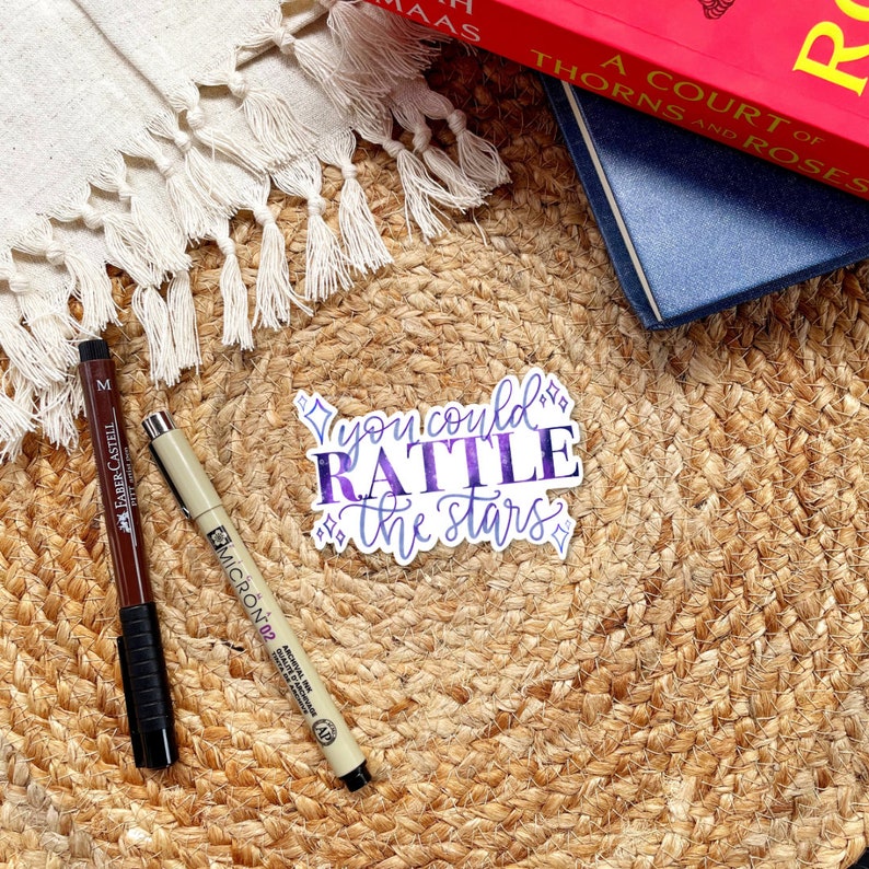 a sticker with the quote you could rattle the stars with purple and blue texture and four pointed stars, a quote by nehemia ytger, Aelins best friend from throne of glass by Sarah j Maas