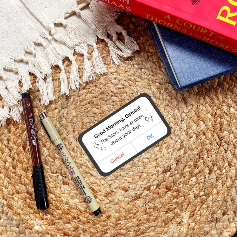 a sticker reminiscent of an iPhone alert, but it says, good morning, Gemini or other zodiac sign, the stars have spoken about your day! in reference to zodiac academy perfect for adding bookish flair to your kindle or laptop