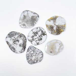 May include: Six grey and white agate slices with a variety of patterns and textures. The slices are irregularly shaped and have a natural, organic look.