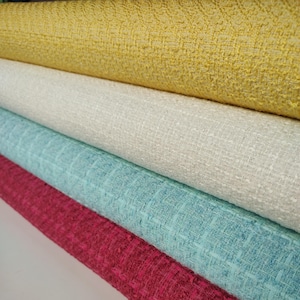 Tela de tweed y bouclé cortada a medida, por metro. Chaquetas y prendas en blanco, amarillo, rosa y azul agua.