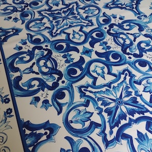 Puede incluir: Tela blanca con un patrón repetitivo azul y blanco de flores estilizadas y remolinos. El patrón recuerda los diseños tradicionales de azulejos portugueses.