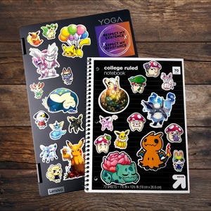 May include: A black Lenovo Yoga laptop and a black college ruled notebook, both covered in various colorful cartoon character stickers. The notebook features 70 sheets and measures 7.5 inches by 10.5 inches. A sticker on the laptop reads: RESPECT MY EXISTENCE OR EXPECT MY RESISTANCE.