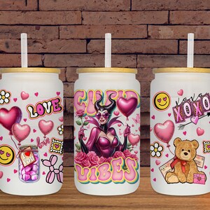 May include: Three white glass tumblers with bamboo lids and straws. Each tumbler features a different design with pink hearts, flowers, and the words "Love", "Vibes", and "XOXO". One tumbler has a cartoon bear.