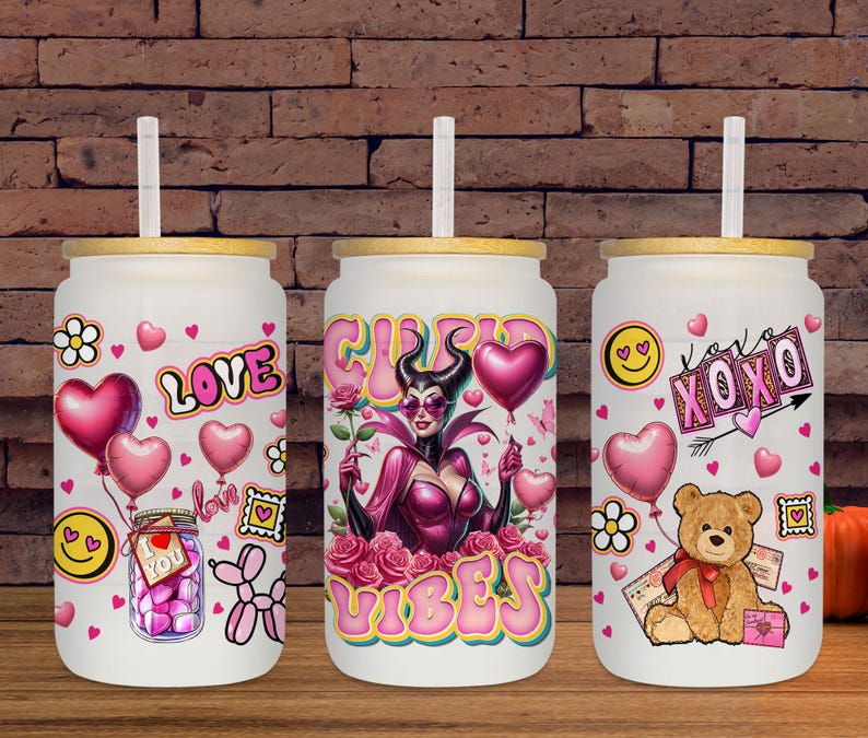 May include: Three white glass tumblers with bamboo lids and straws. Each tumbler features a different design with pink hearts, flowers, and the words "Love", "Vibes", and "XOXO". One tumbler has a cartoon bear.