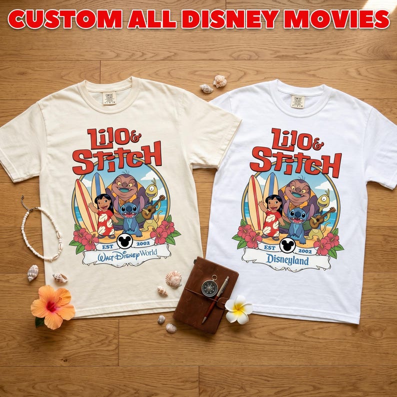 Op de afbeelding: Twee T-shirts, &eacute;&eacute;n cr&egrave;me en &eacute;&eacute;n wit, met een kleurrijk Lilo & Stitch-ontwerp. Het cr&egrave;mekleurige shirt heeft "Walt Disney World" en het witte shirt "Disneyland". Beide shirts tonen "Lilo & Stitch" in het rood. De tekst "CUSTOM ALL DISNEY MOVIES" staat bovenaan.