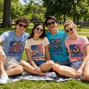 May include: Four people wearing t-shirts with patriotic animal designs and the text "AMERICA 250". The shirts are light blue, beige, turquoise, and pink. The designs include a deer, a rabbit, a bull, and a sloth, all wearing sunglasses.