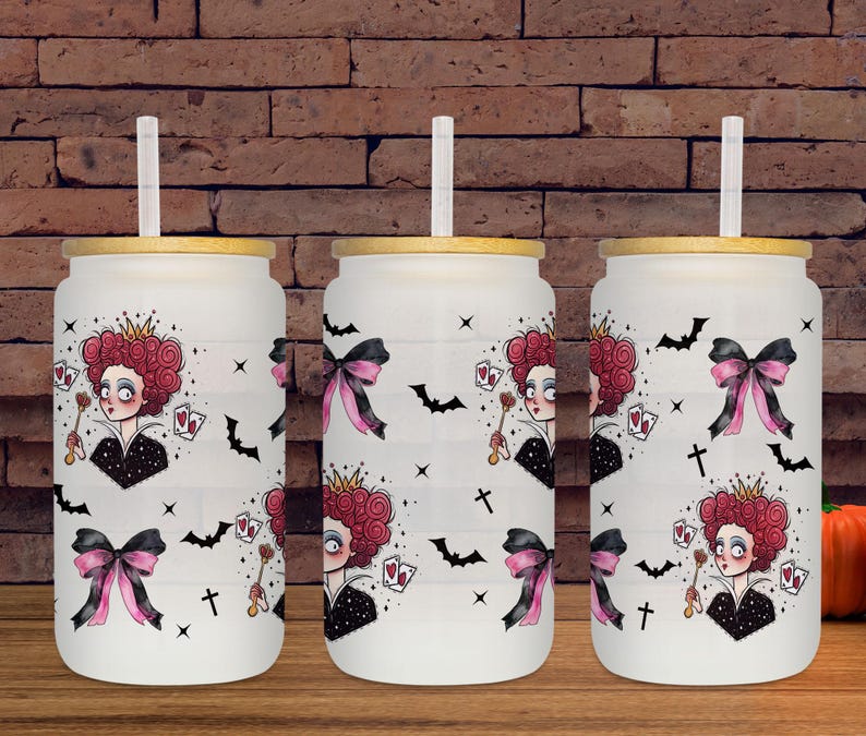 May include: Three white glass tumblers with bamboo lids and straws. Each tumbler features a design of a queen with a red curly hairstyle, playing cards, bats, and bows. The tumblers are on a wooden surface.