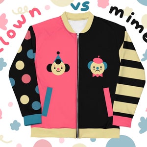 May include: A black and pink reversible bomber jacket with a clown and a mime on each side. The clown is smiling and wearing a red hat and the mime is frowning and wearing a blue beret. The jacket has a zipper closure and a yellow and black striped sleeve.