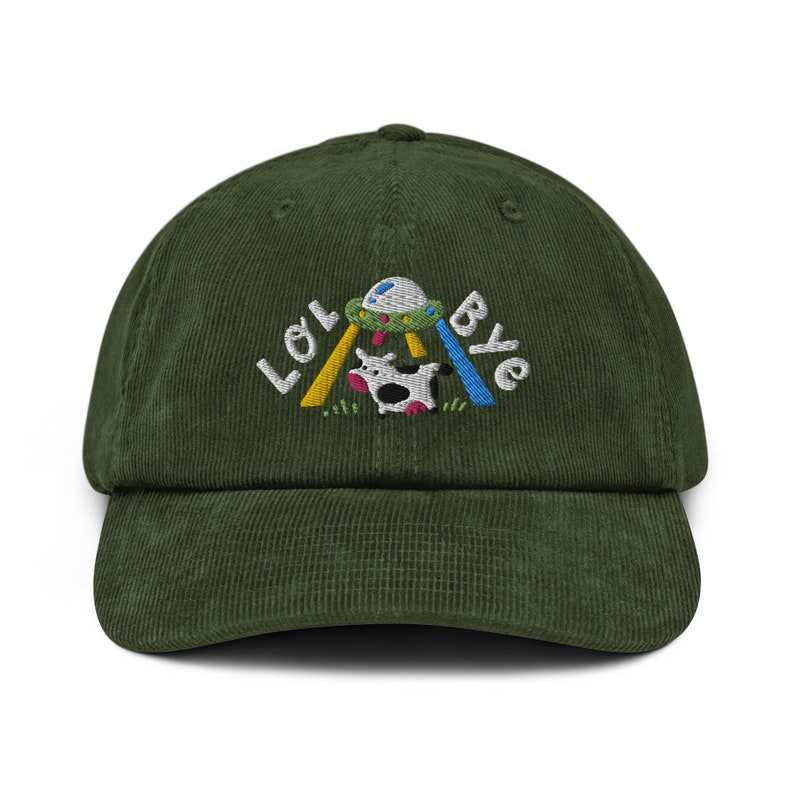 May include: A green corduroy baseball cap featuring an embroidered design of a cow being abducted by a UFO. The design also includes the text "LOL Bye".