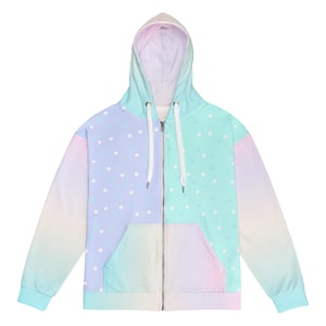 Könnte beinhalten: Ein pastellfarbener Kapuzenpullover mit Reißverschluss, einem weißen Reißverschluss und einem Tupfenmuster auf der Vorderseite. Der Hoodie hat einen Farbverlauf in den Farben Rosa, Blau und Grün.