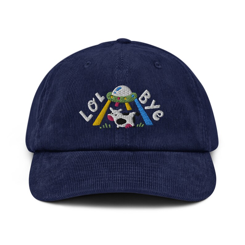 May include: A navy blue corduroy baseball cap with an embroidered design of a cow being abducted by a UFO. The text "LOL Bye" is embroidered above the design.