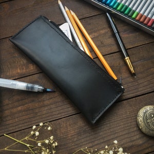 Pencil case zipper, pencils, felt-tip pens. Leather holder for pens. A leather case for pens is an ideal solution for storing pens.