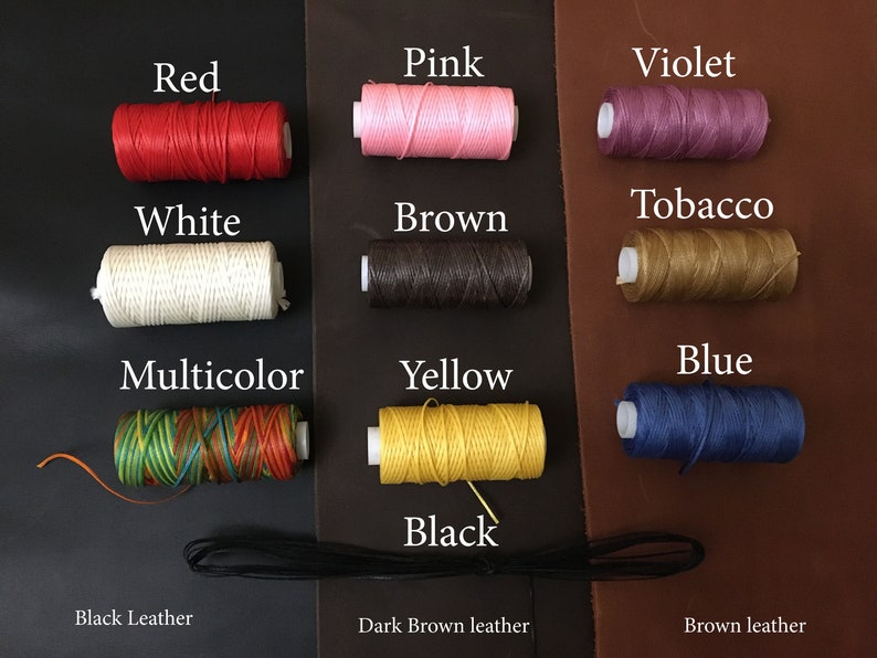 May include: Assortment of spools of waxed thread in various colors, including red, pink, violet, tobacco, white, brown, multicolor, yellow, blue, and black. The spools are arranged in three rows on a background of black, dark brown, and brown leather.
