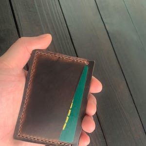 Tarjetero de piel con una ranura para dinero y dos ranuras para tarjetas en cada lado, fabricado en piel “Crazy Horse”.