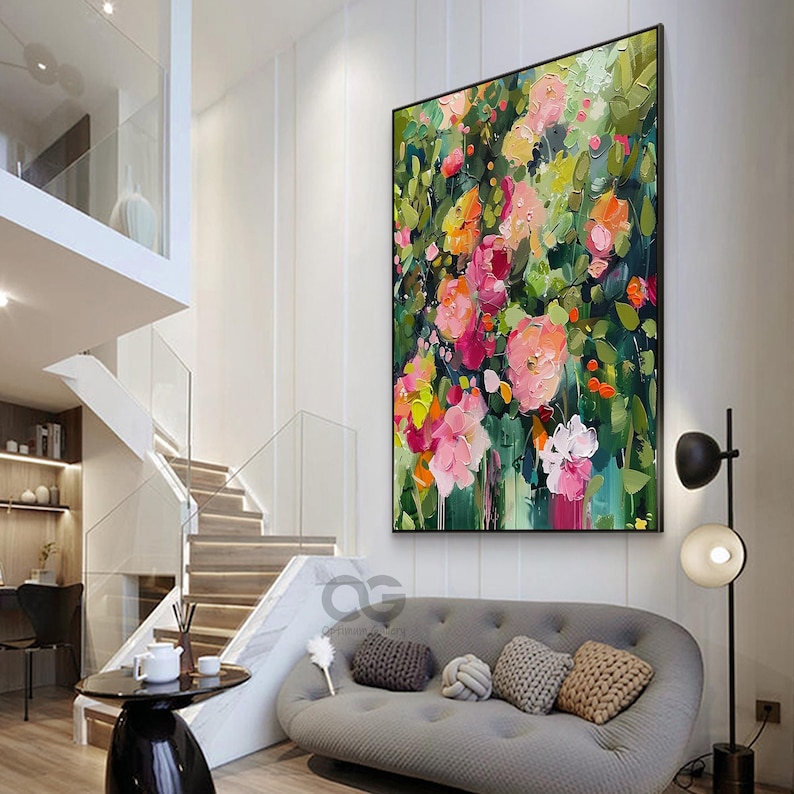 May include: A large abstract painting of a floral bouquet with pink, red, orange, and yellow flowers on a green background. The painting is hanging on a white wall in a modern living room.