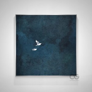 May include: Framed wall art showing two white birds soaring against a dark blue and teal backdrop. The artwork has a watercolour effect, with soft edges and a textured appearance. The birds are detailed with black and grey markings.