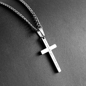 May include: A silver chain necklace with a silver cross pendant. The cross has the inscription "Our love for you never ends".
