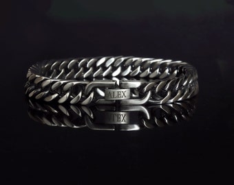 May include: A silver chain bracelet with a clasp that has the word "ALEX" engraved on it.
