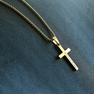 May include: A gold chain necklace with a gold cross pendant. The cross has the words "I'll love you always" engraved on it.