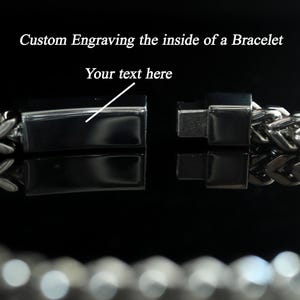 May include: A silver-toned metal chain bracelet with a rectangular clasp mechanism. The image features the text Custom Engraving the inside of a Bracelet and Your text here, pointing to the smooth interior surface of the open clasp.