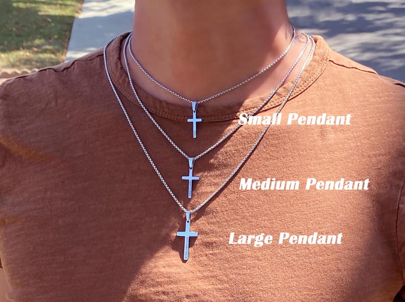 May include: Three silver cross pendants on chains of varying lengths. The smallest pendant is labeled "Small Pendant", the middle pendant is labeled "Medium Pendant", and the largest pendant is labeled "Large Pendant".
