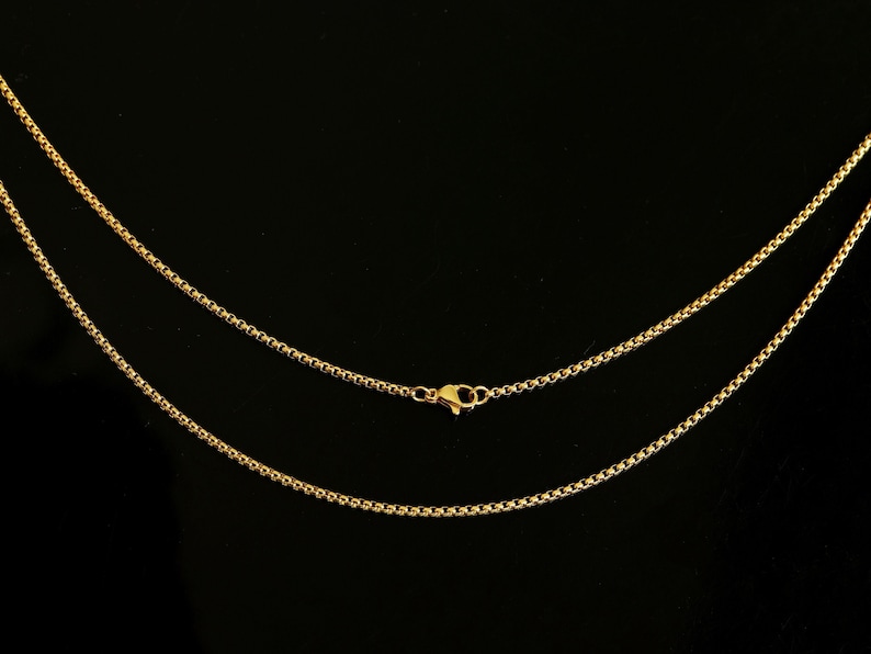 May include: A gold chain necklace with a lobster clasp closure. The chain is made of small, round links.